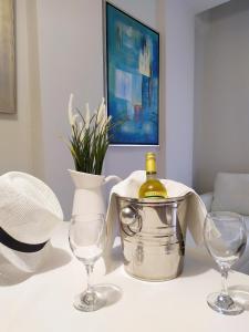 un tavolo con due bicchieri e una bottiglia di vino di Amazing Maisonettes in Skiathos a Città di Skiathos