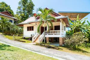 a house with a palm tree in front of it at Tropical Home Koh Phangan in Thongsala