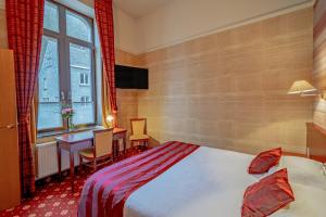 Cette chambre comprend un lit, un bureau et une fenêtre. dans l'établissement Hotel des Comtes Durbuy, à Durbuy