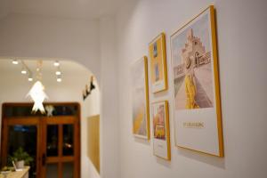 um corredor com fotografias penduradas numa parede em L'amie Hotel & Studio em Da Lat