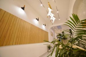 um quarto com uma planta e luzes no tecto em L'amie Hotel & Studio em Da Lat