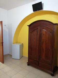 Habitación con puerta de madera y pared amarilla y blanca. en Agriturismo Tenuta Perruzzi, en Leverano