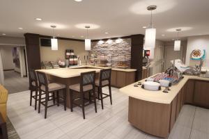 a kitchen with a bar with stools and a counter at Staybridge Suites Columbus - Fort Benning, an IHG Hotel in Columbus