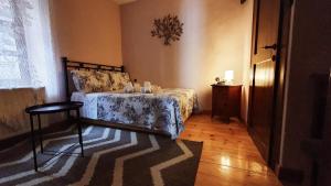a bedroom with a bed and a chair and a rug at Varosi Guesthouse in Edessa