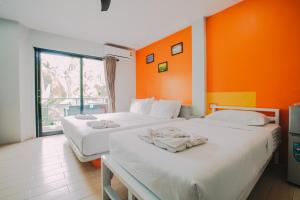 2 camas en una habitación con paredes de color naranja en Good Dream Hotel (Khun Ying House) en Ko Tao