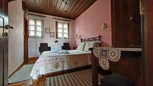 a bedroom with a bed in a room with pink walls at Varosi Guesthouse in Edessa