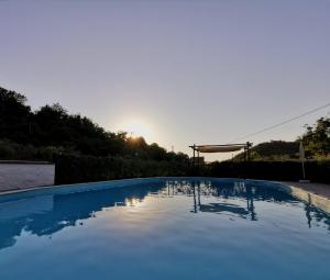 einen Pool mit Sonnenuntergang im Hintergrund in der Unterkunft Molino del prato in Volterra