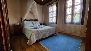 a bedroom with a bed and two windows at Varosi Guesthouse in Edessa