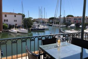 Charming apartment in Port Grimaud في غريمو: طاولة وكراسي على شرفة مع قوارب في الماء