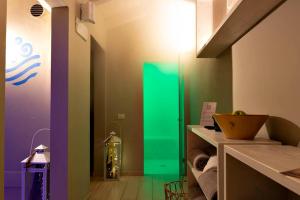 Habitación con paredes coloridas y puerta verde. en Hotel Fiamma en Cesenatico