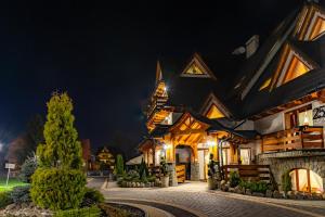 domek w nocy z włączonymi światłami w obiekcie Hotel Burkaty w mieście Białka Tatrzanska