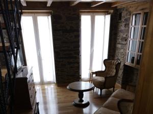a living room with a table and chairs and windows at Casa Lolola in Sada