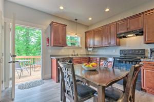 a kitchen with a wooden table with a bowl of fruit on it at Airy Apartment with Deck - Walk to Main Street! in Hendersonville