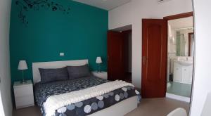 una camera da letto con un letto e una parete verde di Una Stanza In Centro a Gaeta Altre 5 foto