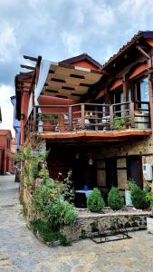a building with a balcony with plants on it at Varosi Guesthouse in Edessa