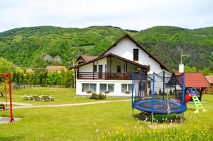 a house with a playground in front of a house at Pensiunea Casa Ady in Bran