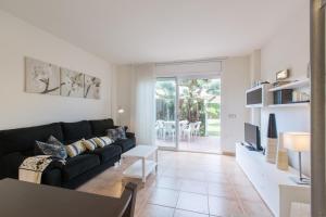 a living room with a black couch and a tv at Casa Ocean by MarCalma in Montroig