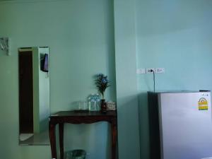 ラムパーンにあるBan Mae Boonthongの客室内の冷蔵庫の横に小さなテーブル