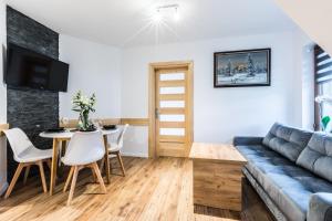 a living room with a blue couch and a table at Apartament Parzenica in Poronin