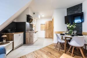 a kitchen and dining room with a table and chairs at Apartament Parzenica in Poronin