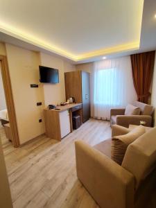 een woonkamer met een bank en een tv in een kamer bij Palmiye Royale Palace in Edirne