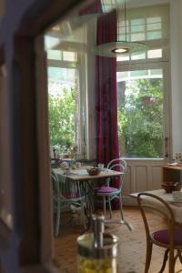 a dining room with a table and chairs and windows at B&B Villa Emma in Ghent