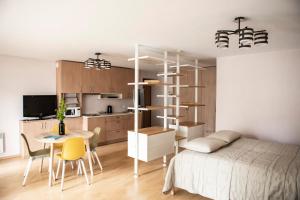 a bedroom with a bed and a table and a kitchen at NIDA in Nida