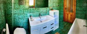 a bathroom with a sink and a green tiled wall at Elegante trilocale con garage, terrazzo e vista montagne in Bardonecchia