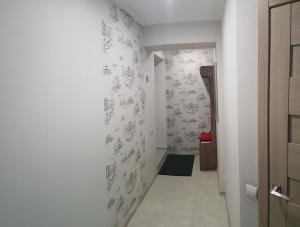 a hallway with white walls with drawings on the wall at LOFT studio Apartment on Teslenkа street in Kryvyi Rih