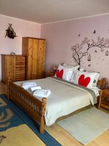 Babaház في Bodajk: غرفة نوم مع سرير مع شجرة على الحائط
