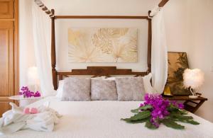 Un dormitorio con una cama blanca con flores. en Villa Samar Altea Grupo Terra de Mar, alojamientos con encanto, en Altea