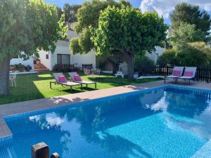 a swimming pool in a yard with chairs and a house at Bed & Breakfast Wine & Cooking Penedès in Pla del Panadés