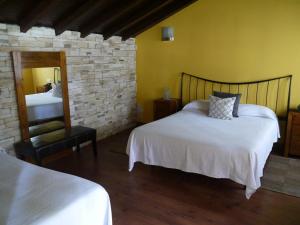 a bedroom with two beds and a mirror at Hotel Rural Isasi in Gordexola