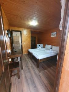 a bedroom with a large bed in a wooden room at Daiana Residence Cabane in Turda