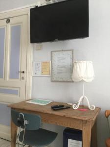 a desk with a lamp and a monitor on a wall at B&B-Fine Fleur in Zottegem