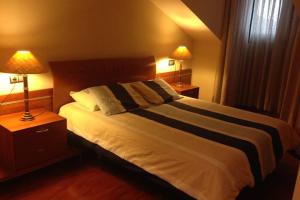 1 dormitorio con 1 cama grande y 2 lámparas en Atico centro Oviedo 3hab+garaje+terraza+wifi en Oviedo