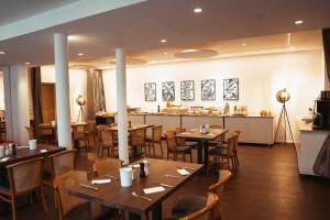 ein Restaurant mit Holztischen und -stühlen und einer Bar in der Unterkunft Hotel Feyrer in Senden