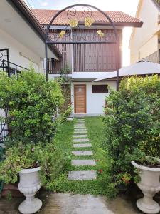 einen Gehweg, der zu einem Haus mit einem Tor führt in der Unterkunft Chiang Mai Heritage House in Chiang Mai