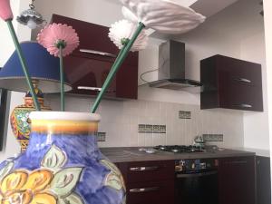 um vaso colorido com flores numa cozinha em Villa Grace em Patti