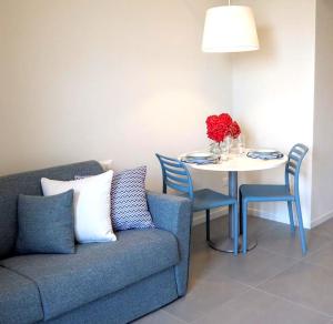 a living room with a couch and a table with a vase of flowers at La finestra "sul Lago" in Predore