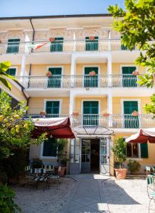 a building with a balcony and tables and chairs at Hotel Miranda in Varazze