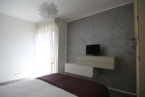1 dormitorio con 1 cama y TV en la pared en Appartamenti Morfeo, en Pisa