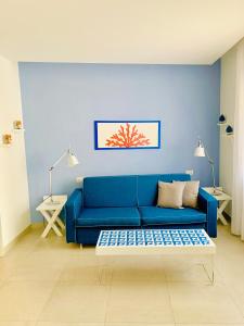 a blue couch in a living room with a table at Al Parco Primavera B&B in Sorrento