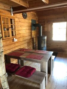 a wooden cabin with a table and a stove at Ferienhaus Sterling in Luckau +9 photos