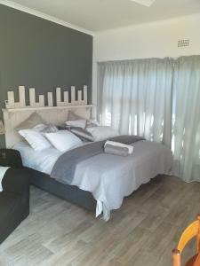 a bedroom with a large bed with white pillows at 19 on Micro Avenue in Strand
