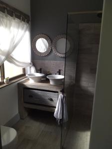a bathroom with two sinks and two mirrors at 19 on Micro Avenue in Strand