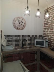 a kitchen with a sink and a clock on the wall at 19 on Micro Avenue in Strand