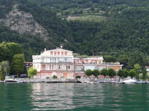 a large building on the water in front of a mountain at La finestra "sul Lago" in Predore