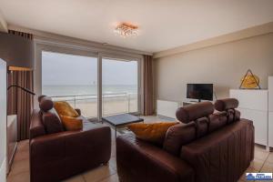 a living room with two leather chairs and a view of the ocean at Golvenzang 0401 in Koksijde