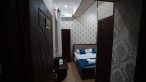 タシュケントにあるSapphire Hotelの小さなベッドルーム(青い枕のベッド付)